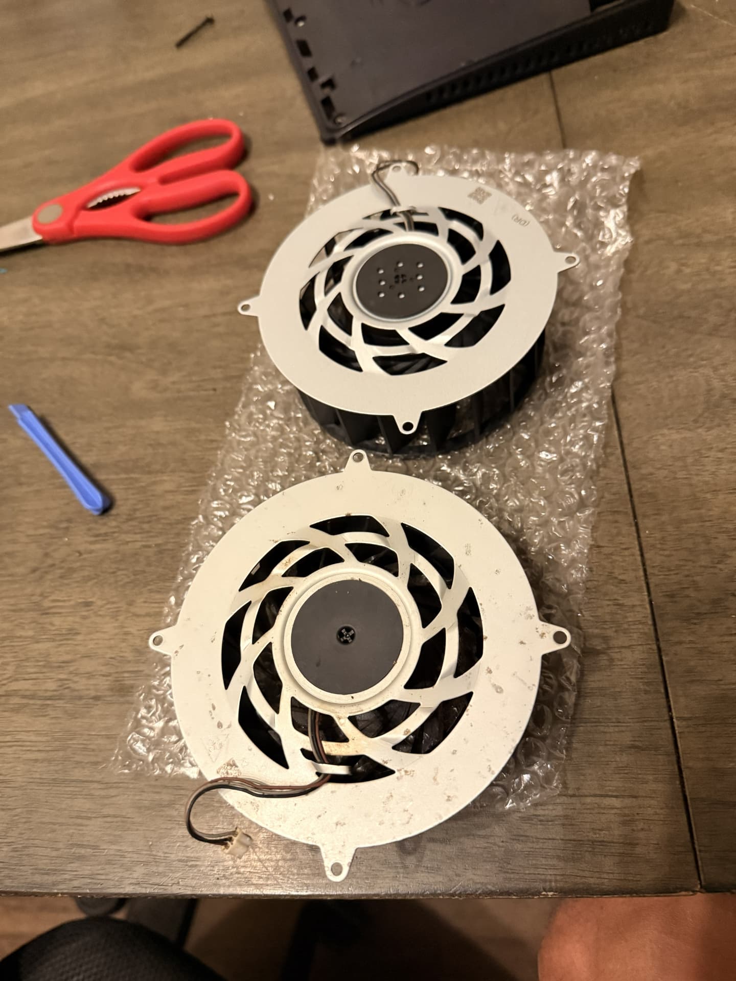 Replacement — The worn fan was removed and a replacement fan was prepared for installation. (PlayStation 5)