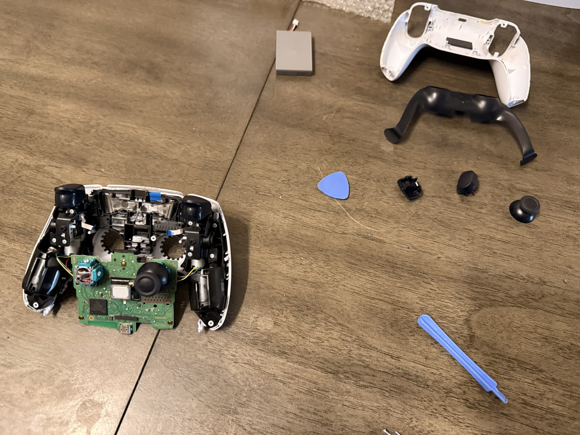 During Repair — The controller disassembled with the shell and internal components separated. (PS5 DualSense Wireless Controller)