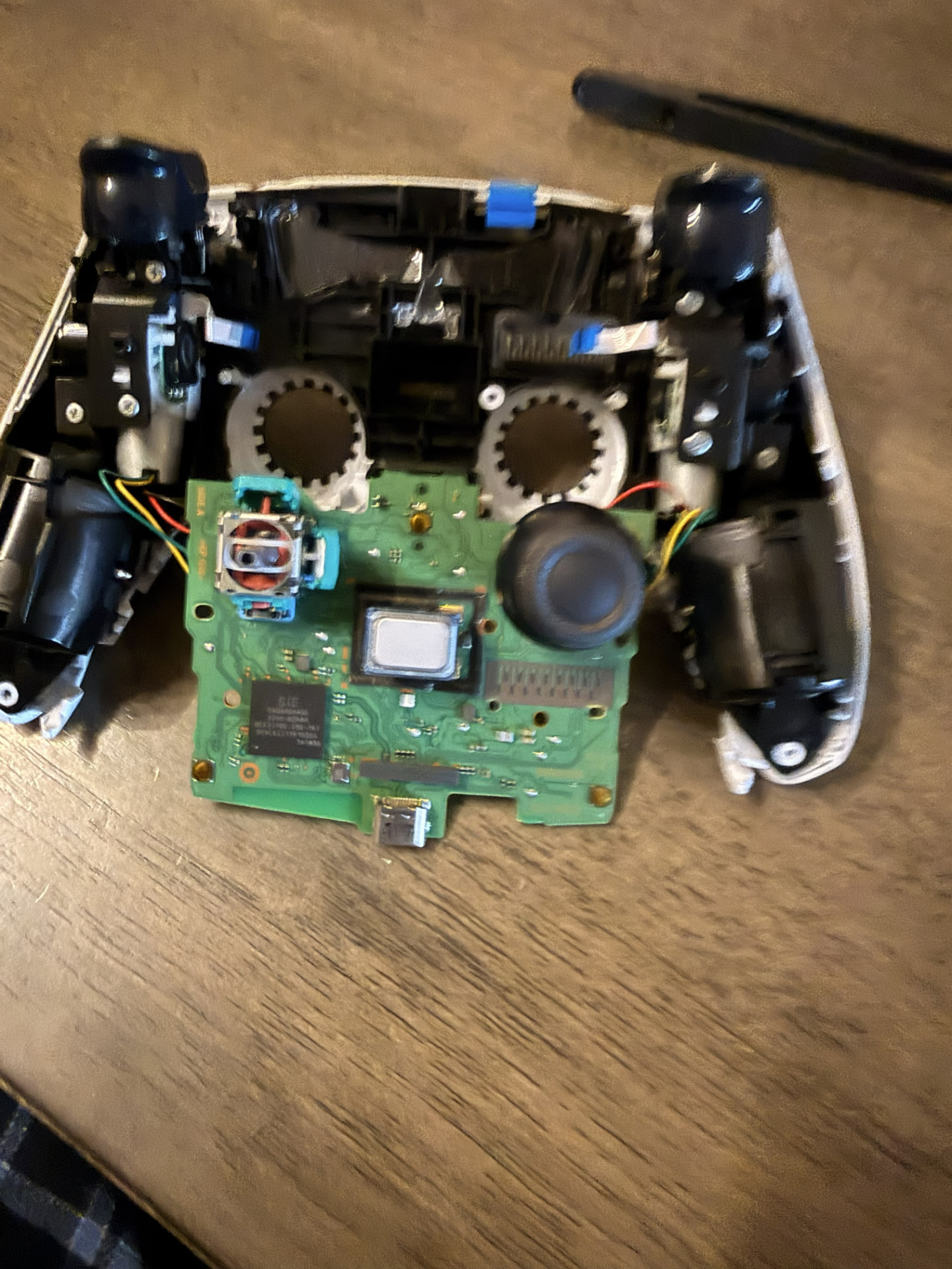 During Repair — Close-up of the internal circuit board and analog stick components. (PS5 DualSense Wireless Controller)