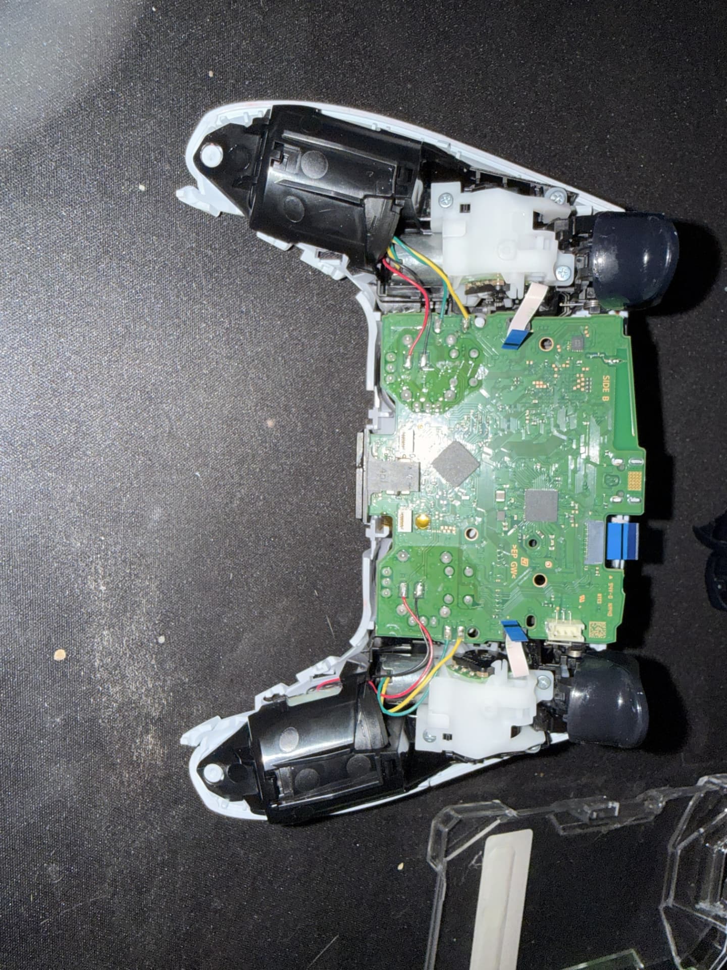 During Repair — The controller opened with the internal motherboard and components exposed. (PS5 DualSense Wireless Controller)